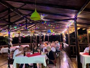 a group of people sitting at tables in a restaurant at Hotel Pedacito de Cielo in Boca Tapada