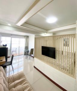 a living room with a television on a wall at Impress Town Condo at Nimman 704 in Chiang Mai