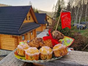 a plate of cupcakes on a table with a flag at Domki po balu in Rycerka Dolna