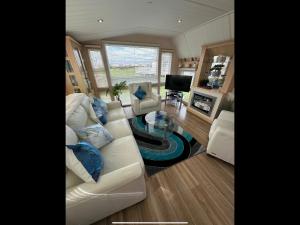 a living room with a white couch and blue pillows at M9 luxury lodge style holiday home waterside Ingoldmells Skegness Santanavan 11 in Ingoldmells