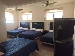 Una habitación con cuatro camas y un televisor de pantalla plana. en La Casona, San José del Cabo, en San José del Cabo 33 fotos más