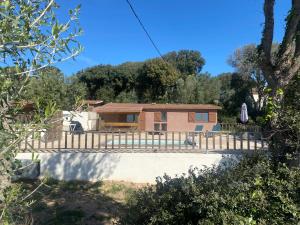 une maison avec un portail et une clôture dans l'établissement Petit chalet d’été avec piscine privée chauffée, à Bonifacio