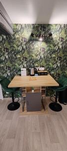 a wooden table in front of a green wall at L'Oasis Amiénoise - Le Quai Amiénois in Amiens