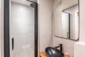 ein Bad mit einem schwarzen Stuhl und einer Dusche in der Unterkunft M034 Studio bohème centre ville in Annemasse