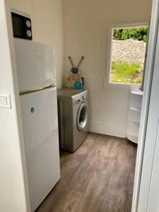 une buanderie avec un réfrigérateur et une machine à laver dans l'établissement Petit chalet d’été avec piscine privée chauffée, à Bonifacio