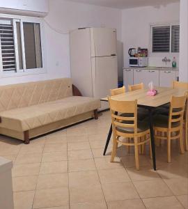 a living room with a couch and a table with chairs at BLAGO home Los Angeles 2 in Eilat