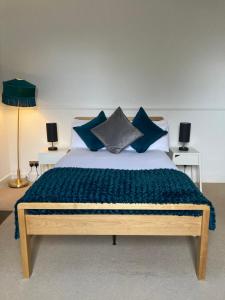 a bedroom with a large bed with blue pillows at The Old Manor House,Carnoustie in Panbride