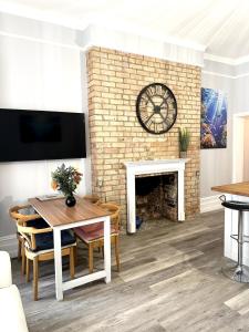 a living room with a table and a fireplace at The Bournemouth Haven - Brought to you by Coastline Retreats - Grand 2 bedroom luxury apartment - 3 mins walk to beach - Superfast Wifi - Sleeps 6 in Bournemouth