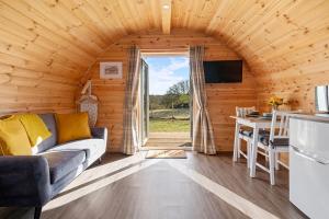 een woonkamer met een bank, een keuken en een tafel bij The Pods at 7 Black Crofts in Oban