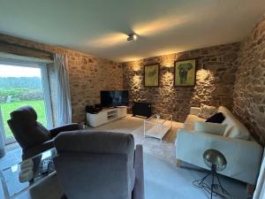 a living room with a couch and a tv at Casa La Pedrosa - Tedin in Cee