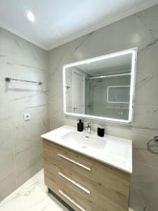 a white bathroom with a sink and a mirror at Beach Retreat 2 BR Apartment in Fuengirola