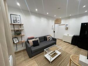 a living room with a couch and a tv at T3 cosy proche de CDG et Paris - Le Bourget in Le Bourget