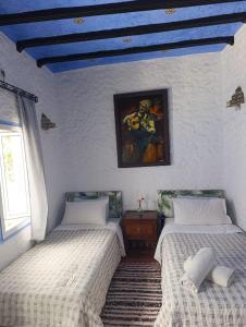 two beds in a room with a blue ceiling at hotel dar lalla khadouj in Chefchaouen +82 photos