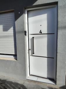 a white garage door with the number four on it at Depto Civora 4 in Villa Regina