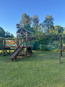 a playground in a park with a swing at Cabañas in La Reja
