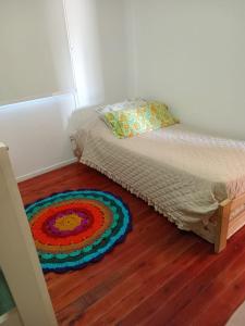 a bed in a room with a rug on the floor at Cabañas in La Reja +9 photos