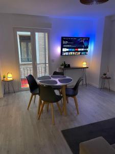 a dining room with a table and chairs and a tv at ZaragozaHome El Tubo - Ideal Familias - Parking in Zaragoza