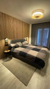 a bedroom with a large bed with a black and white blanket at ZaragozaHome El Tubo - Ideal Familias - Parking in Zaragoza