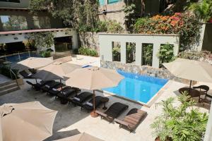 an outdoor swimming pool with umbrellas and lounge chairs and a pool at Casa Andina Premium Golf Los Incas in Lima