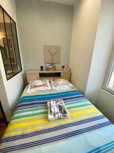 a small bedroom with a bed with a towel on it at Charmant Petit studio proche Centre et Plage in Banyuls-sur-Mer