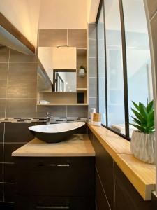 a bathroom with a sink and a large window at Charmant Petit studio proche Centre et Plage in Banyuls-sur-Mer