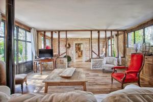 a living room with a red chair and a table at Belle demeure - Centre Ville - Jardin Botanique in Cabourg