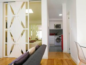 Una sala de estar con un sofá y una cocina. en Beautiful & Unique Alfama flat, en Lisboa