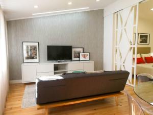 Una sala de estar con un sofá y un televisor. en Beautiful & Unique Alfama flat, en Lisboa