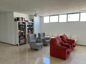 a living room with a red couch and chairs at Magnífico Apartamento en La Carihuela, Torremolino in Torremolinos