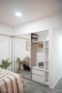 a bedroom with a bed and a white closet at Altos de Centro Chivilcoy 3 in Chivilcoy +2 photos