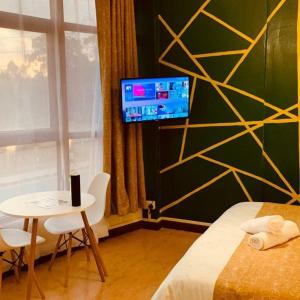 a bedroom with a bed and a table and a tv at Golden Touch SPA & Massage in Kigali