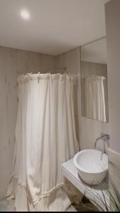 a white bathroom with a sink and a mirror at Altos de Centro Chivilcoy 4 in Chivilcoy