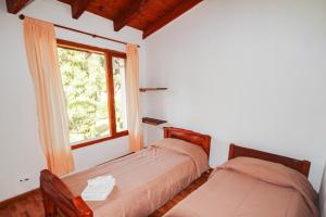 two beds in a room with a window at Mont Blanc Bungalows in San Carlos de Bariloche