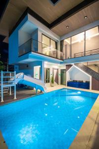 ein Haus mit einem Swimmingpool mit Rutsche in der Unterkunft Pool Villa Sura Designer in Nong Prue