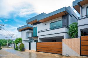 ein Haus mit einem Holzzaun davor in der Unterkunft Pool Villa Sura Designer in Nong Prue