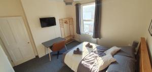 ein Schlafzimmer mit Bett, Schreibtisch und Fenster in der Unterkunft Simple, cosy and comfortable 3 beds in Kings Lynn