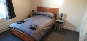 ein Schlafzimmer mit einem großen Bett mit einem hölzernen Kopfteil in der Unterkunft Simple, cosy and comfortable 3 beds in Kings Lynn
