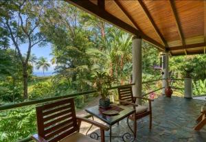 a porch with chairs and a table and a view of the ocean at Casa Selva in Dominicalito