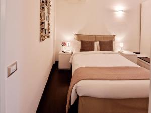 a bedroom with a large white bed and two night stands at Donna Rosa - Main Avenue in Taormina +35 photos