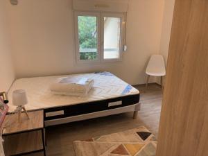 a bed in a room with a window at Appartement T3 - Plage à 500m in Saint-Nazaire