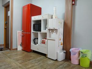 a kitchen with a white refrigerator and a red cabinet at Gangga's House in Daegu