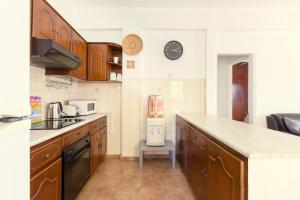 a kitchen with wooden cabinets and a counter top at Spacious Larnaca Beach Apartment in Larnaka +33 photos