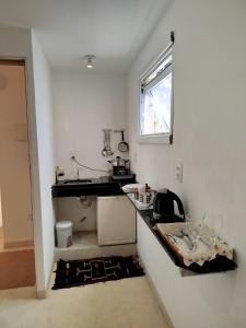 a small kitchen with a counter and a window at Apartamento Solar das Artes in Morro de São Paulo