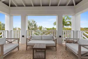 a living room with two chairs and a couch on a porch at Romora Bay Resort & Marina in Harbour Island