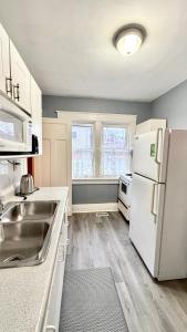 a kitchen with a sink and a white refrigerator at Adorable 2-bedroom unit with jacuzzi beside falls in Niagara Falls