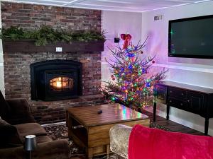 a living room with a christmas tree and a fireplace at Renovated farmhouse on snowmobile trail with firepit & mountain views 10 min from Bretton Woods in Carroll