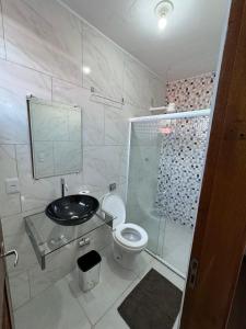 a bathroom with a shower and a toilet and a sink at Suítes como uma onda in Abraão