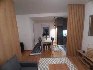 a living room with a table and a kitchen at Apartman Beograd Mir i Komfor in Belgrade