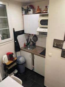a small kitchen with a sink and a microwave at Appartement Montrouge in Montrouge