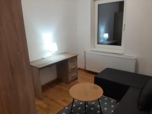 a small living room with a desk and a table at Apartman Beograd Mir i Komfor in Belgrade